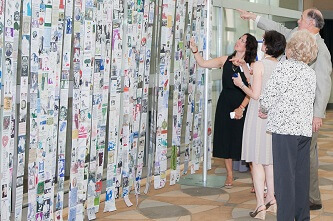 Guests view the Living Legacy Tapestry at the 20th anniversary event.